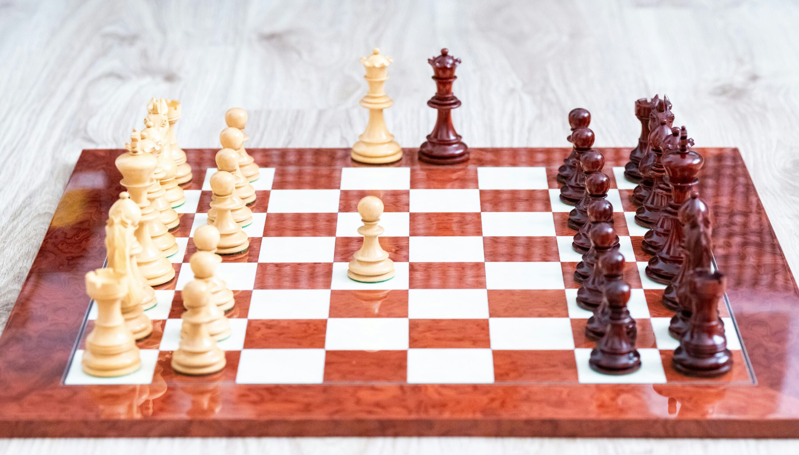 A wooden chess board with pieces on it